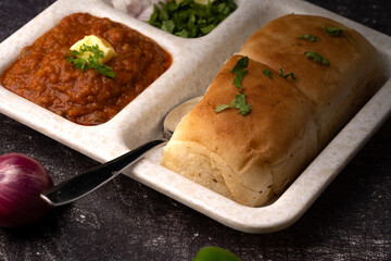 Mumbai Style Pav or paav bhaji is a fast food dish from India, consists of a thick vegetable curry served with a soft bread roll, served in a plate