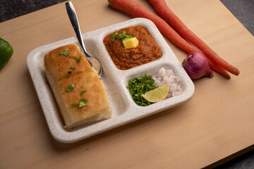 Mumbai Style Pav or paav bhaji is a fast food dish from India, consists of a thick vegetable curry served with a soft bread roll, served in a plate
