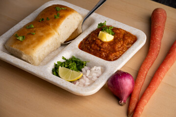 Mumbai Style Pav or paav bhaji is a fast food dish from India, consists of a thick vegetable curry served with a soft bread roll, served in a plate