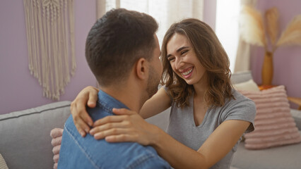 Couple smiling together on sofa in cozy apartment room creating intimate and joyful moment
