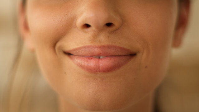 Close up face lips of unrecognizable Indian Arabian woman girl female lady smiling smile sensuality plastic surgery beauty lipstick make up health medicine cropped view indoors feminine cosmetology
