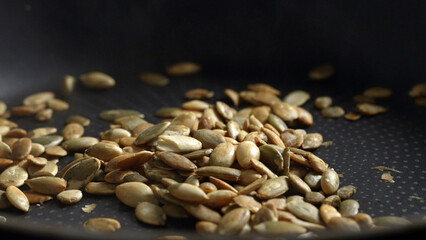 Fototapeta premium Pumpkin seeds are fried in a frying pan.