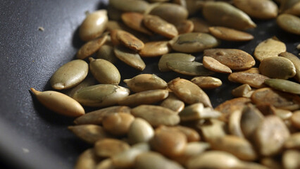 Pumpkin seeds are fried in a frying pan.