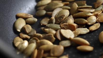 Pumpkin seeds are fried in a frying pan.