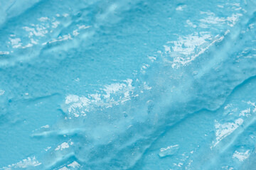 Transparent blue cosmetic gel texture close up. Abstract cosmetic background
