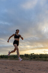 Girl running on the mountain at sunset. Copy space.	