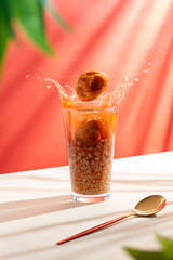 Mote con huesillo traditional Chilean drink on white table with orange background