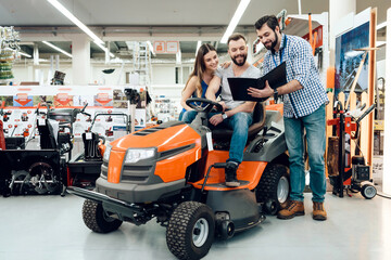 Salesman is showing couple of clients new cleaning machine in power tools store.