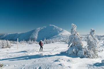 Narciarz skiturowy w Karkonoszach na tle Śnieżki