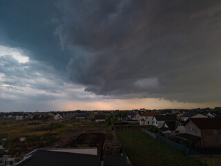Rural settlement on the plain filmed from drone in cloudy summer weather. Beginning of a strong...