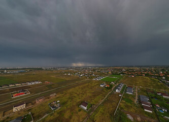 Rural settlement on the plain filmed from drone in cloudy summer weather. Beginning of a strong...