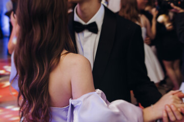 High school graduates dancing on prom, waltz and classical ball slow dance in dresses and suits on...