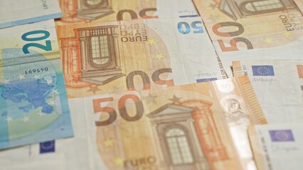 Euro banknotes from the european union featuring 50 and 20 euro denominations scattered on a surface