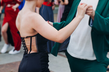 High school graduates dancing on prom, waltz and classical ball slow dance in dresses and suits on...