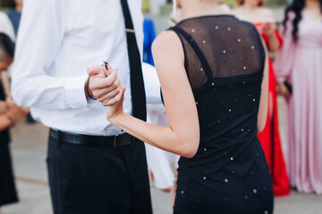 High school graduates dancing on prom, waltz and classical ball slow dance in dresses and suits on...