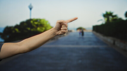Man pointing hand forward in urban street with blurred background implying outdoor direction and...
