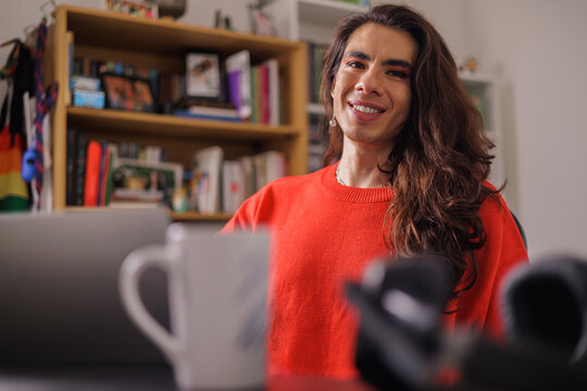 Face of happy non-binary person while doing their job looking at camera
