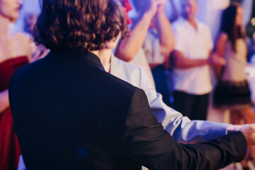 High school graduates dancing on prom, waltz and classical ball slow dance in dresses and suits on...