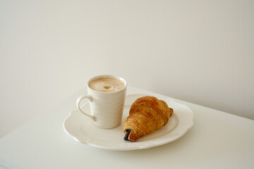 Coffee cup and fresh croissant creative layout on white background. Healthy eating and sweet food concept. French breakfast. 