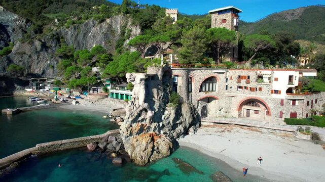 Italy Monterosso al Mare aerial drone orbit of Giant statue holding building on beach. Il Gigante Neptune sculpture Fegina beach Cinque Terre Liguria travel 4k scenery