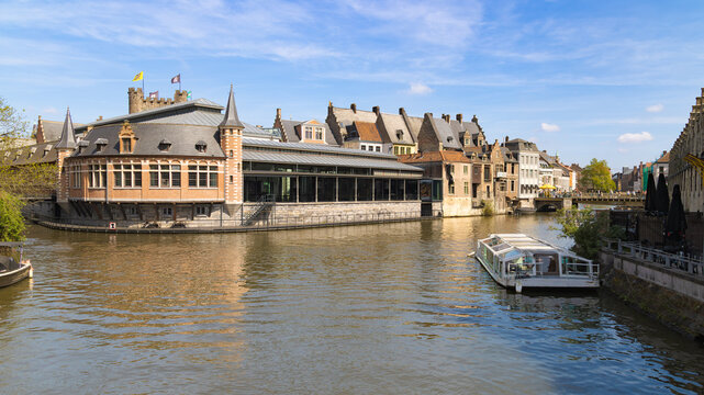 Canal Harmony en Gante, B&eacute;lgica, con edificios hist&oacute;ricos reflejados en el agua y un barco tur&iacute;stico.