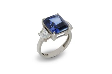A closeup of a sophisticated women's ring featuring a large, brilliant blue stone, accented with small diamonds on the silver band on a transparent background
