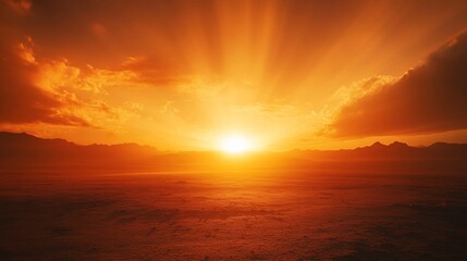 Fototapeta premium Vibrant sunset over a vast, flat desert landscape with sun rays bursting through clouds.