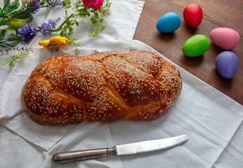 Easter sweet bread, homemade tsoureki braid and colorful Easter eggs on the table