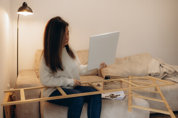 Woman Assembling Furniture While Reviewing Instructions in a Cozy Living Room