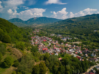 Picturesque rural landscape with houses gathered at the foot of the mountain in summer in Romania seen from above