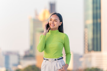 Fototapeta premium Young Asian Woman Talking on Phone in Modern City Outdoors