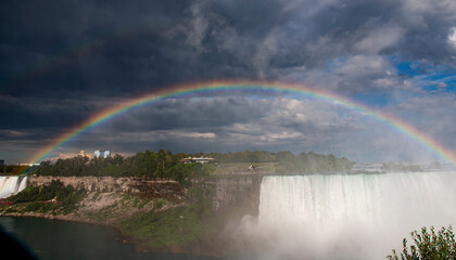  A Rainbow Arches Over Niagara Falls During an Overcast Day in Summer