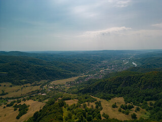 Picturesque landscape with high hills and forests at the foot of the Carpathian Mountains in sunny weather in summer season