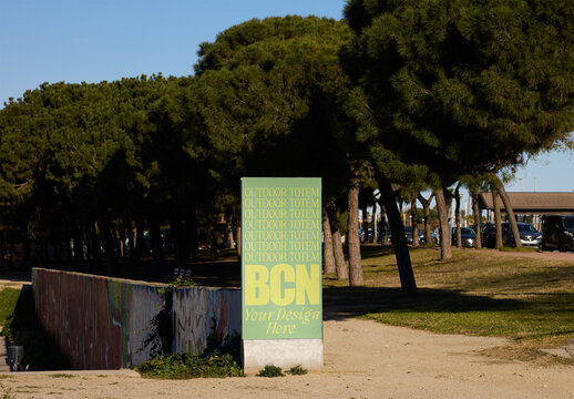 Blank poster stands in Barcelona park, ready to provide useful information to visitors enjoying the outdoor space.