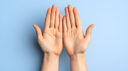 Hands open with palms facing up against light blue background, symbolizing openness and receptiveness. image conveys sense of calm and tranquility