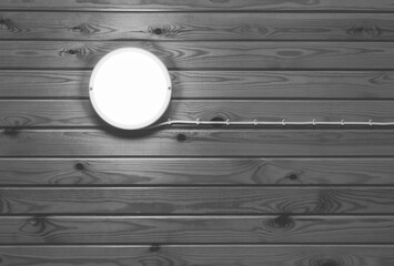 turned on round lamp on a wooden wall