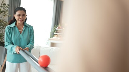 Grandmother holding pipe and carrying ball rolling game for exercise to improve eye, hand coordination or enhance focus and concentration. Elder couple providing stress relieve. Healthcare. Myrmidon.