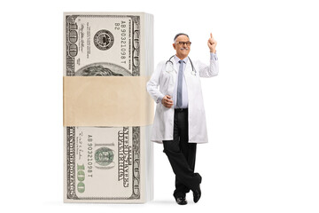 Mature male doctor with a big stack of money pointing up