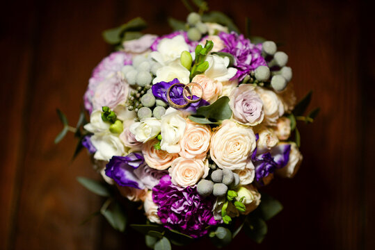 Wedding bouquet with rings and purple floral accents