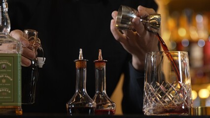 Closeup hand bartender holding jigger to measure liquor sugar into mixing glass ingredients alcohol preparation creative mixed cocktail. Special refresh drink showcasing nightlife mixology. Vinosity.