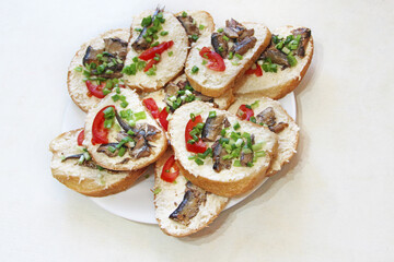 toasts with sprats and green onions on plate. Cold appetizers. Sandwiches