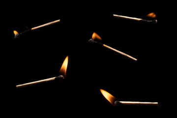 Lit falling match on a black background.