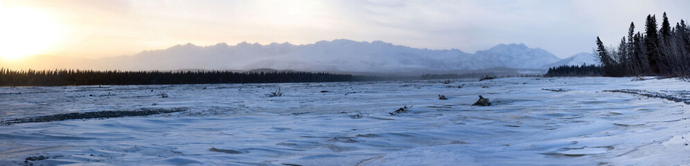 Naklejka premium Sun rising behind mountains in Alaska on the winter solstice
