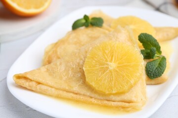 Delicious Crepes Suzette on white textured table, closeup