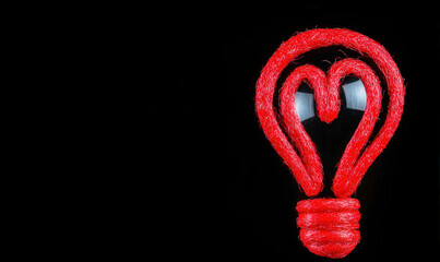 Red heart within a light bulb shape symbolizing love, creativity, and innovative ideas on a black background for artistic and inspirational concepts