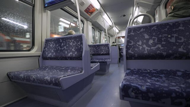 Empty subway car in Hamburg, Germany. Modern, clean and well-lit interior with blue patterned seats and sleek handrails. Quiet, futuristic urban transport scene, travel and infrastructure concepts. 