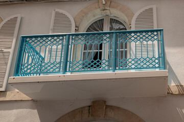 detail of the facade of a building with a blue fence and window