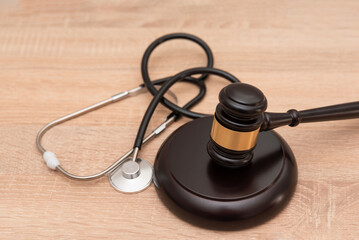 Gavel and medical stethoscope on wooden background, law and healthcare concept.
