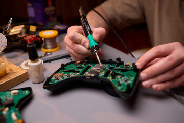Hands Carefully Repairing a Circuit Board with a Soldering Tool for Electronics Projects