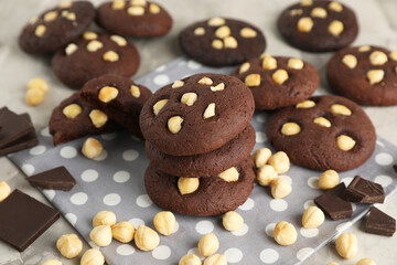 Tasty chocolate cookies with hazelnuts on table, closeup